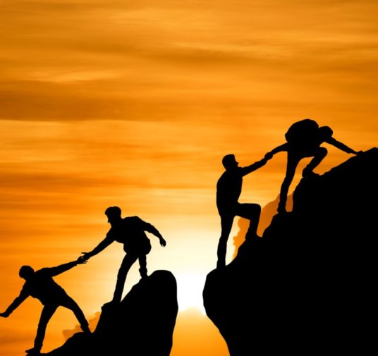 A Group of People Helping Each Other in Hiking