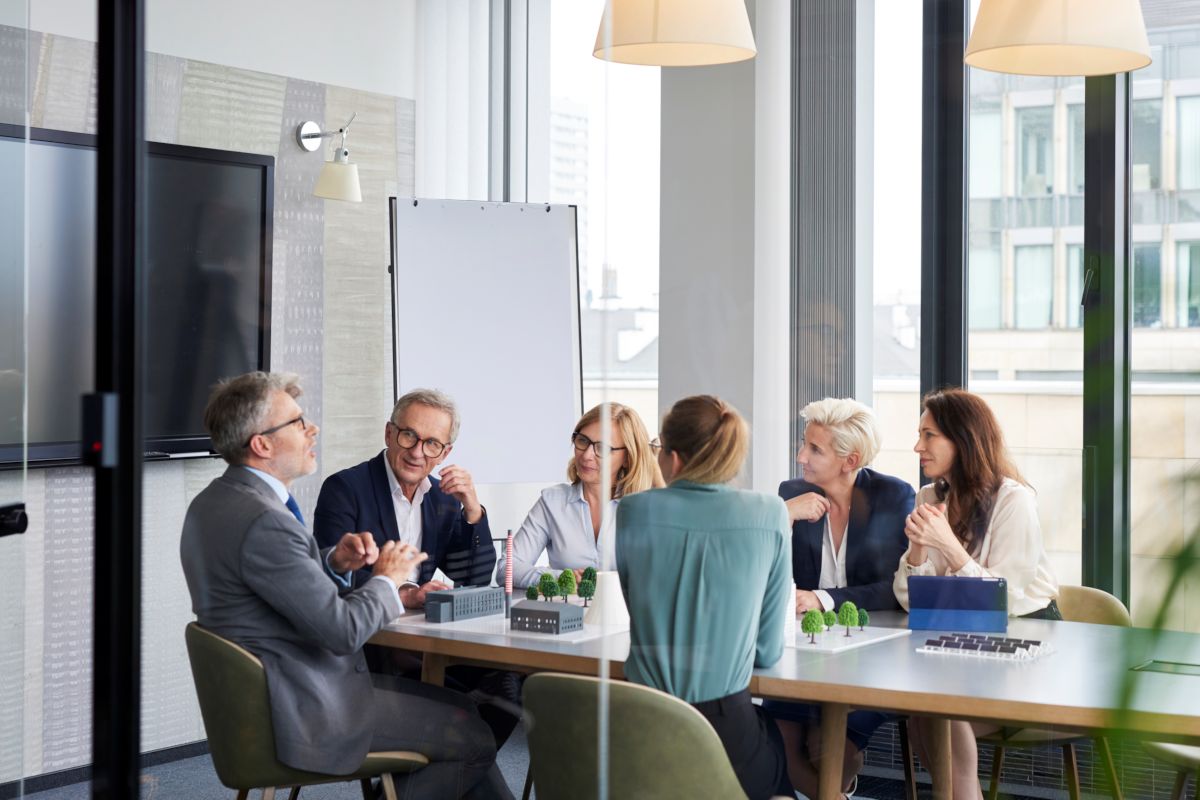 A Board Room With People Discussing Over Plans